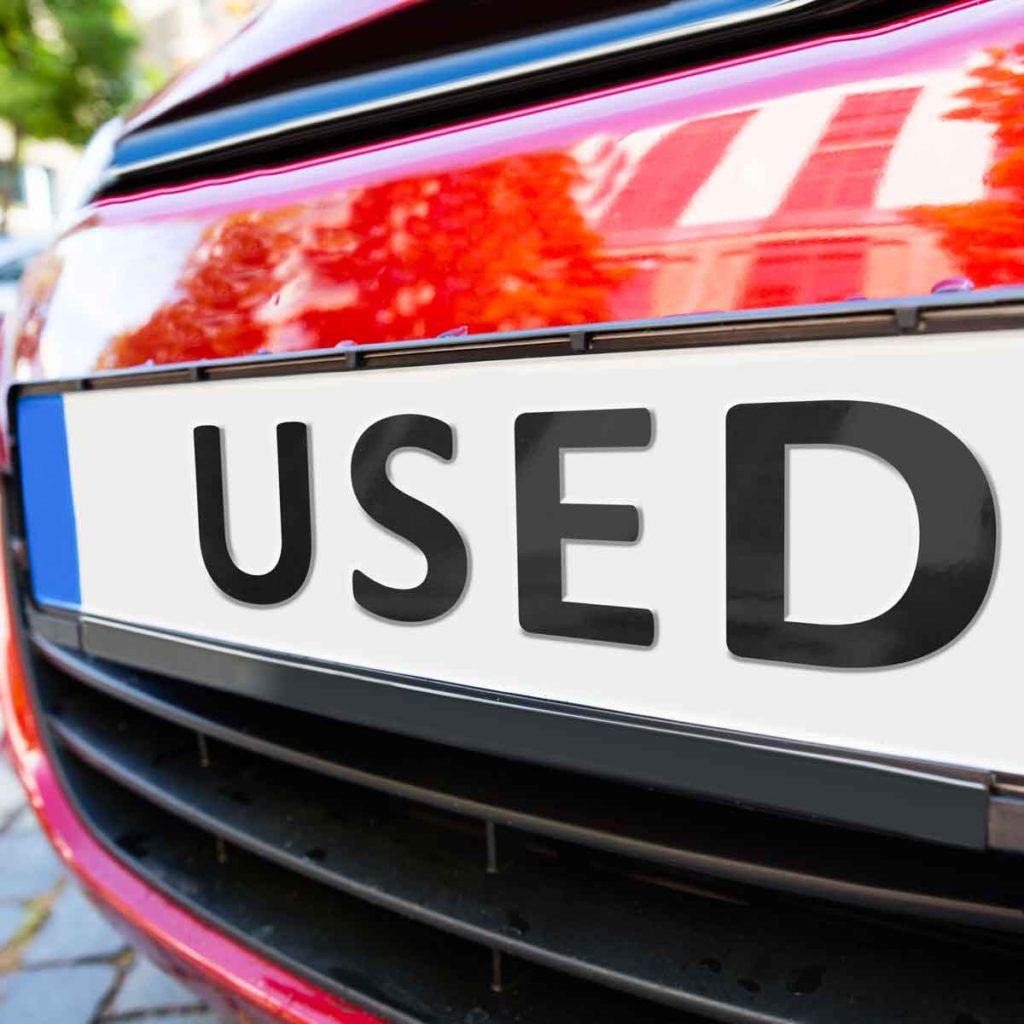 Front detail of a red car with the word used where the numberplate would be - what to look out for when buying a used car