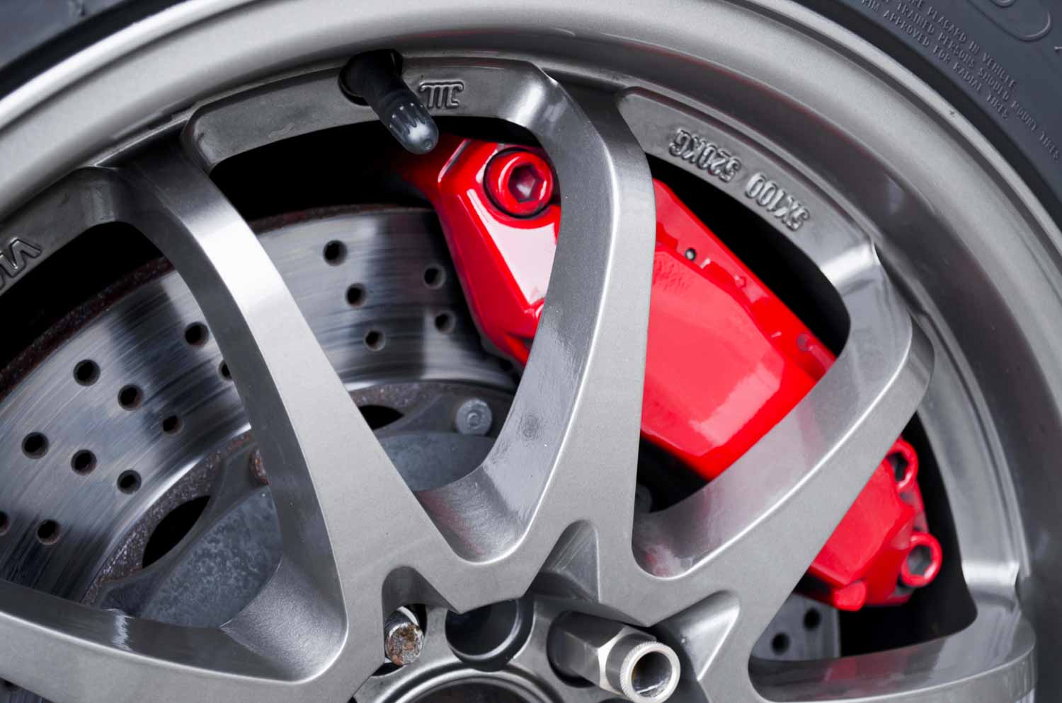 Close up of a car wheel with the red of the brakes just visible - checking the brakes during a test drive is a key part of viewing a used car